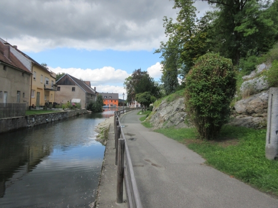 Wir gehen am Fluss entlang zu einer Felswand